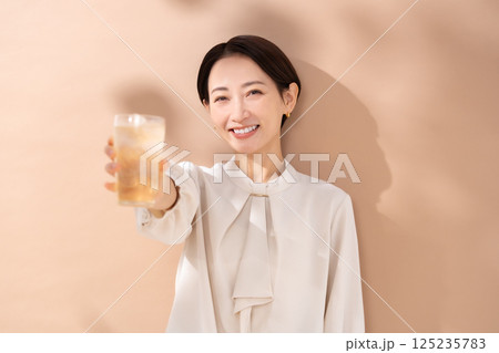 ハイボールを飲む女性　日差し 125235783