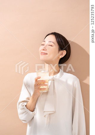 ハイボールを飲む女性　日差し 125235793