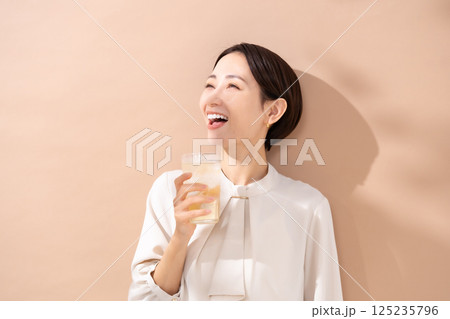ハイボールを飲む女性　日差し 125235796
