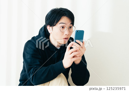 スマホを持つ若い男性 125235971