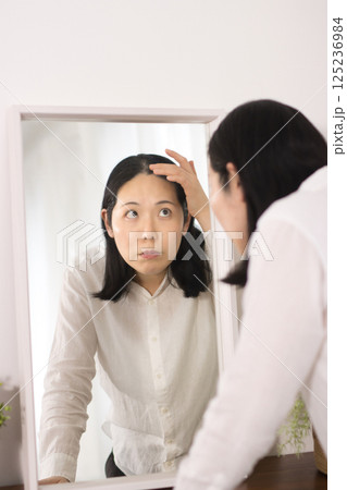 髪の毛が気になるミドル女性 125236984