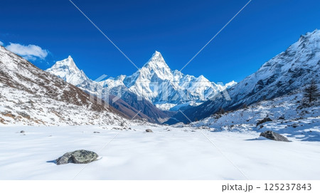 A mountain range with snow-covered peaks and a clear blue sky A mountain range with snow-covered peaks and a clear blue sky 125237843