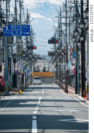 冬の朝の光が差し込む商店街と残雪の山 125238765