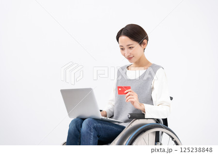 車椅子でネットショッピングをする女性 125238848