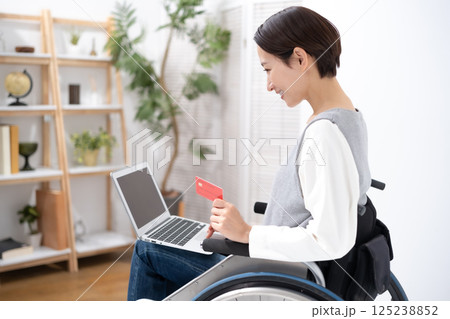車椅子でネットショッピングをする女性 125238852