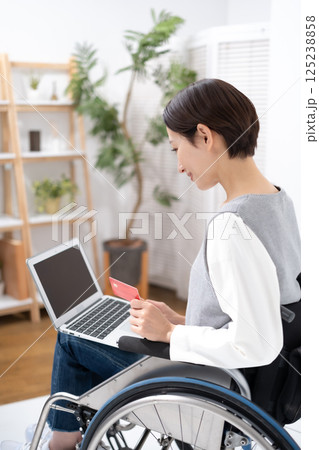 車椅子でネットショッピングをする女性 車椅子でネットショッピングをする女性 125238858