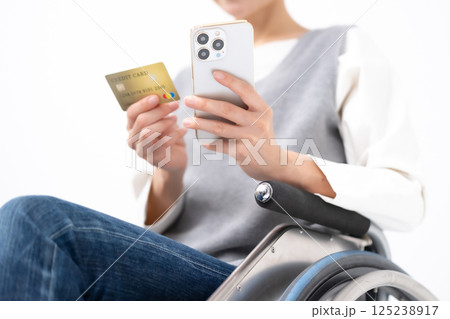 スマホとカードを持つ車椅子の女性 手元 スマホとカードを持つ車椅子の女性 手元 125238917