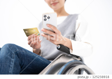 スマホとカードを持つ車椅子の女性　手元 125238918