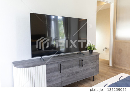 Comfortable room with modern LED TV and wooden CABINET. 125239033