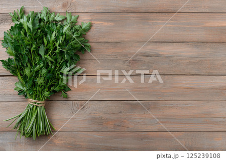 Basil, thyme and parsley bundled with a string on rustic wood, symbolizing culinary preparation 125239108