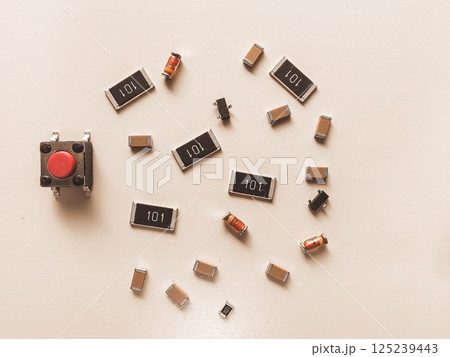 Surface-mount resistors, diodes and push button on white background 125239443