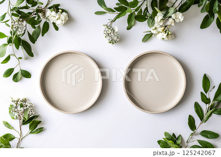 A minimalist dining setup with two plates and floral accents, featuring clean tones and perfect A minimalist dining setup with two plates and floral accents, featuring clean tones and perfect 125242067