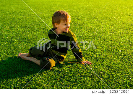 The child goes in for sports at the stadium. The boy training before playing football. The child goes in for sports at the stadium. The boy training before playing football. 125242094
