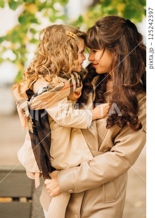 Joyful moment between mother and daughter in autumn park setting 125242397