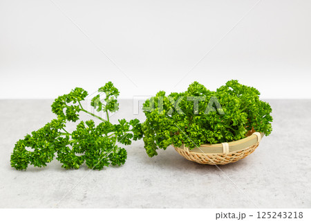 パセリの素材写真　白背景の中のパセリ　小さいざるに入っている 125243218