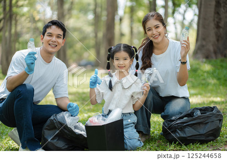 Happy Asian family collecting plastic bottles at the park. Happy Asian family collecting plastic bottles at the park. 125244658