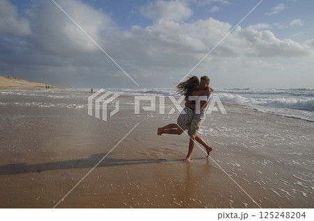Couple Embracing on Sandy Beach Shoreline 125248204