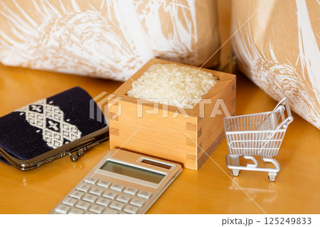 米価 お米の価格 家計のイメージ、枡に入ったお米と米袋、ショッピングカート、計算機、財布、一万円札 125249833