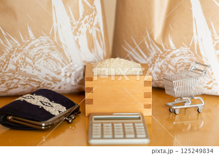 米価 お米の価格 家計のイメージ、枡に入ったお米と米袋、ショッピングカート、計算機、財布、一万円札 125249834