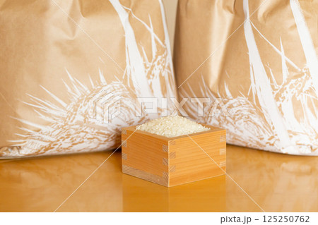 テーブルに置かれた米袋と枡に入ったお米 テーブルに置かれた米袋と枡に入ったお米 125250762
