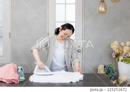 アイロンをかけるミドル女性 125251672