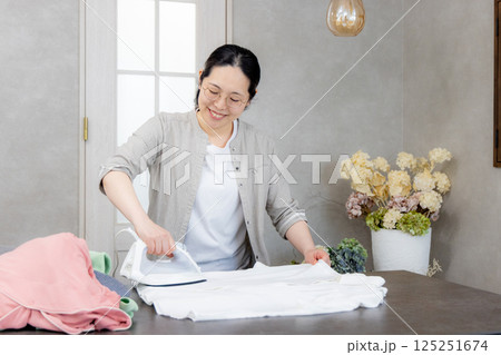 アイロンをかけるミドル女性 125251674