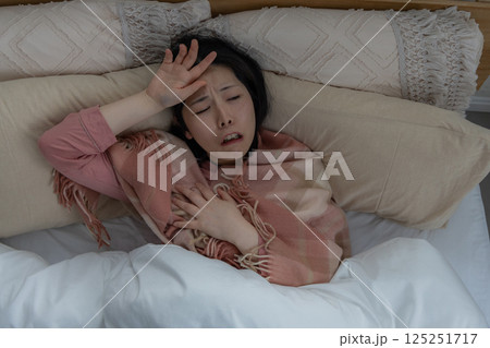 体調不良で頭を抱える女性 125251717