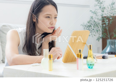 お肌を見て悩むミドル女性 お肌を見て悩むミドル女性 125251726