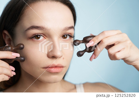 Facial massage technique using wooden tools for relaxation and beauty care Facial massage technique using wooden tools for relaxation and beauty care 125252820