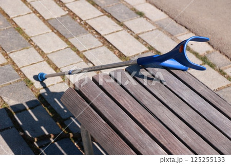 A blue cane is leaning against a wooden bench A blue cane is leaning against a wooden bench 125255133