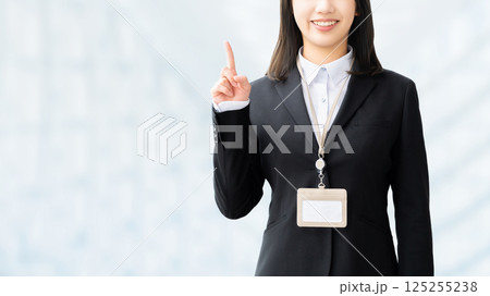 人差し指を立てて案内する笑顔の女性・ビジネスウーマン 人差し指を立てて案内する笑顔の女性・ビジネスウーマン 125255238