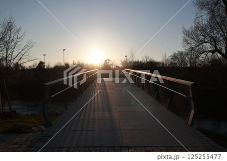 A bridge with a sun shining on it 125255477