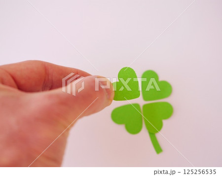 A hand holding a green paper heart with four other hearts A hand holding a green paper heart with four other hearts 125256535