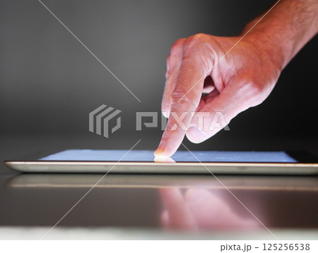 A hand is pointing at a tablet screen 125256538