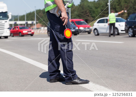 Police officer controlling traffic on the highway 125256831