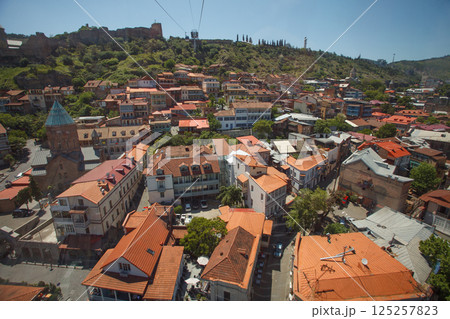 Landscape of old town Tbilisi on the background of blue sky and green mountains Landscape of old town Tbilisi on the background of blue sky and green mountains 125257823
