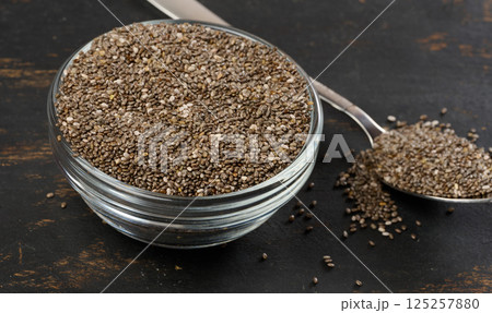 Clear glass bowl filled with dry chia seeds, top view 125257880