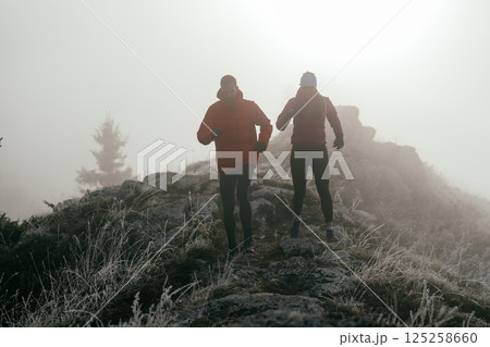 Trail running couple man and woman running on a mountain path Trail running couple man and woman running on a mountain path 125258660