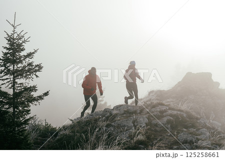 Trail running couple man and woman running on a mountain path 125258661
