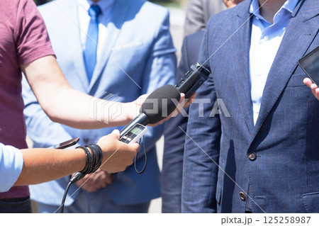 Group of journalists recording speech of business person or politician during press conference 125258987