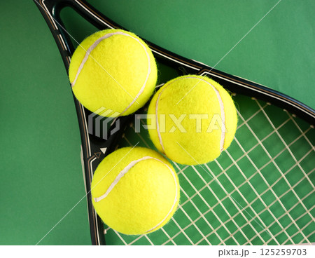 Top view of tennis racket and balls on green background.Sport concept Top view of tennis racket and balls on green background.Sport concept 125259703