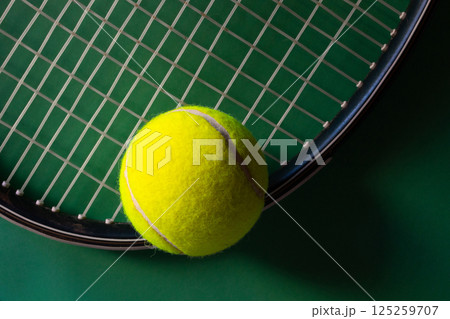 Tennis racket and balls on dark green background. Soft sidelight Tennis racket and balls on dark green background. Soft sidelight 125259707