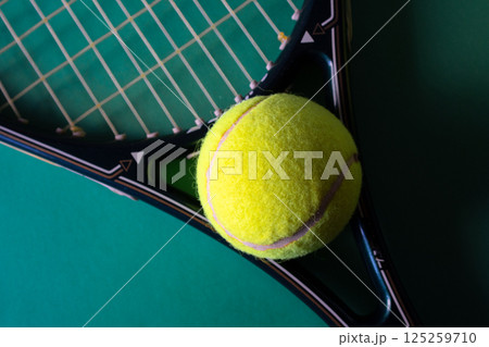 Tennis Racket and ball on brilliant green wallpaper, flat lay. Tennis Racket and ball on brilliant green wallpaper, flat lay. 125259710