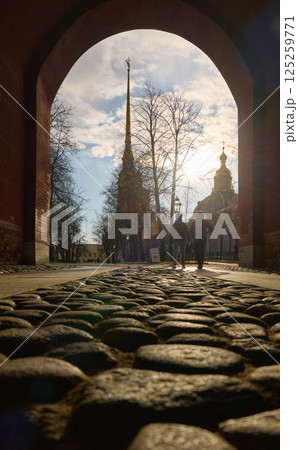 View on the Peter and Paul Fortress spire through arch at sunset 125259771