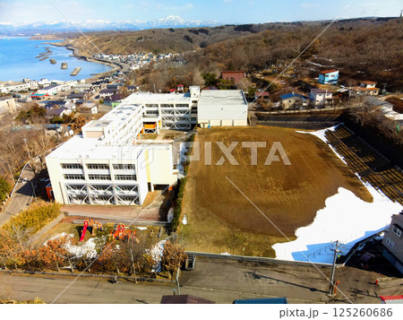 早春の北海道江差町で町立江差小学校の風景を空撮 早春の北海道江差町で町立江差小学校の風景を空撮 125260686
