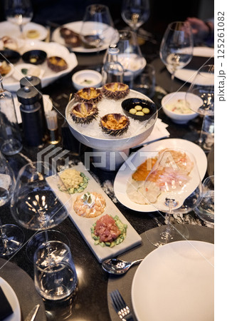 Champagne tasting, Wine glasses are on the table, stylish table setting, wine is poured from a bottle and decanter, sparkling wine bubbles, snacks, people smell the aroma and taste the wine Champagne tasting, Wine glasses are on the table, stylish table setting, wine is poured from a bottle and decanter, sparkling wine bubbles, snacks, people smell the aroma and taste the wine 125261082