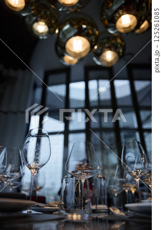 Champagne tasting, Wine glasses are on the table, stylish table setting, wine is poured from a bottle and decanter, sparkling wine bubbles, snacks, people smell the aroma and taste the wine 125261085