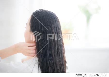 髪のケアやヘッドスパなどをする女性　オイルやトリートメントをする	 125261325