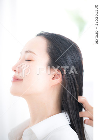 髪のケアやヘッドスパなどをする女性　オイルやトリートメントをする 125261330
