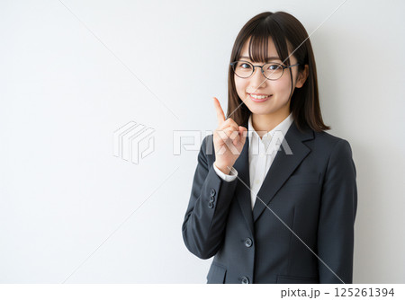 ワンポイントを指し示すめがねをかけた笑顔の女性 125261394